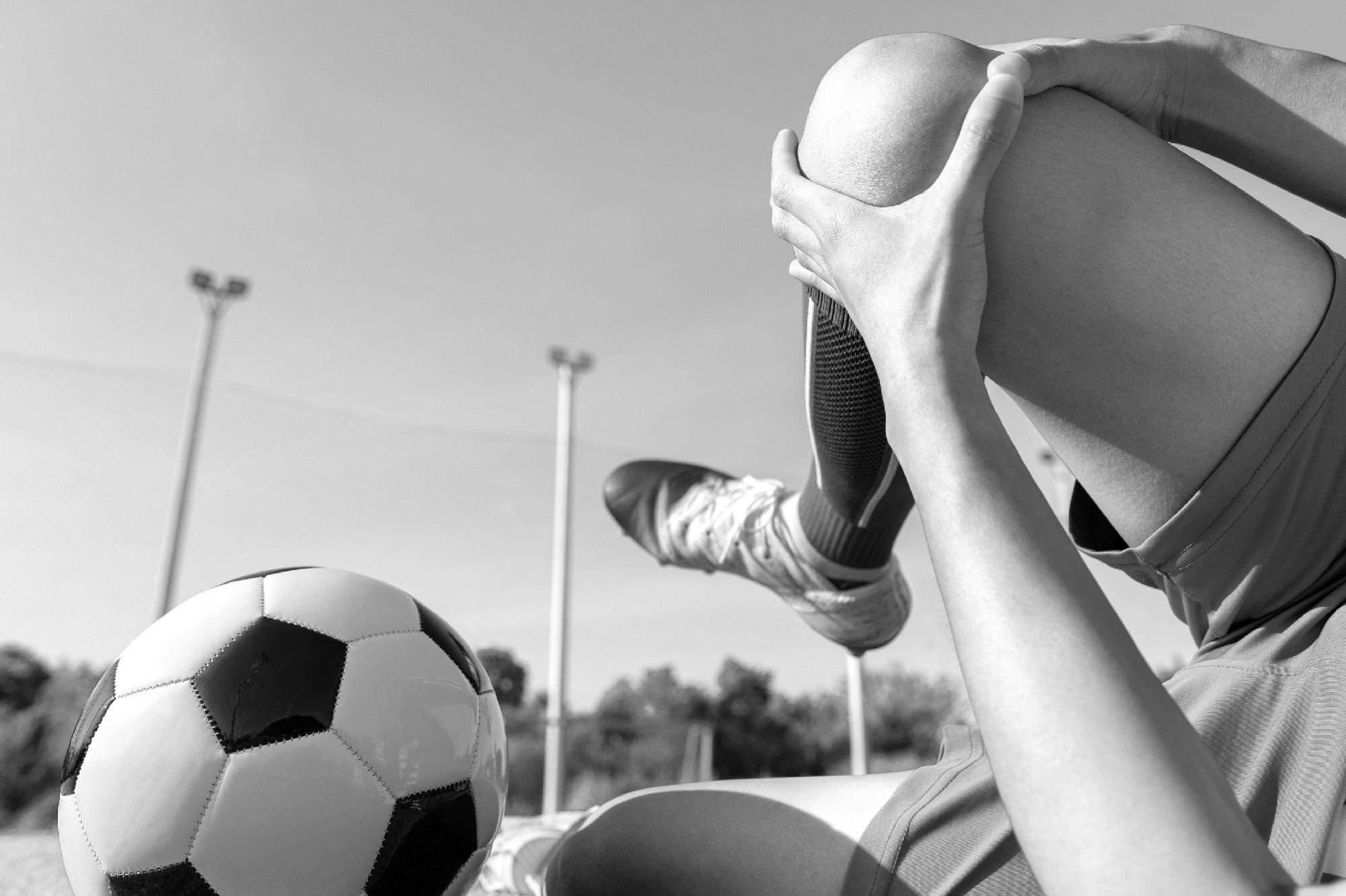 Jugador de fútbol dolorido tendido sobre el terreno de juego